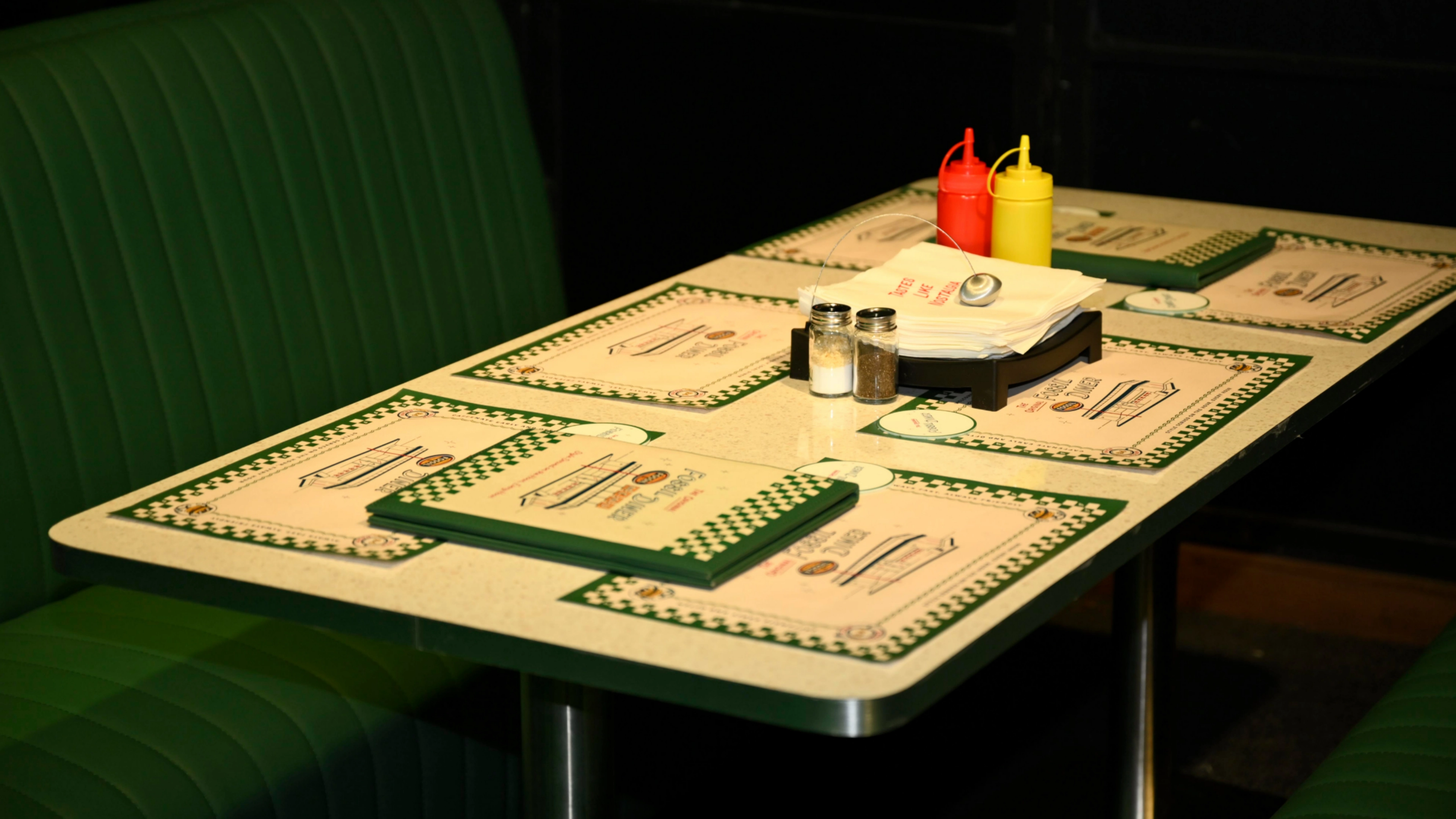 Fossil Diner activation - Retro-inspired diner booth with red vinyl seating, chrome details, and authentic 1950s Americana decor