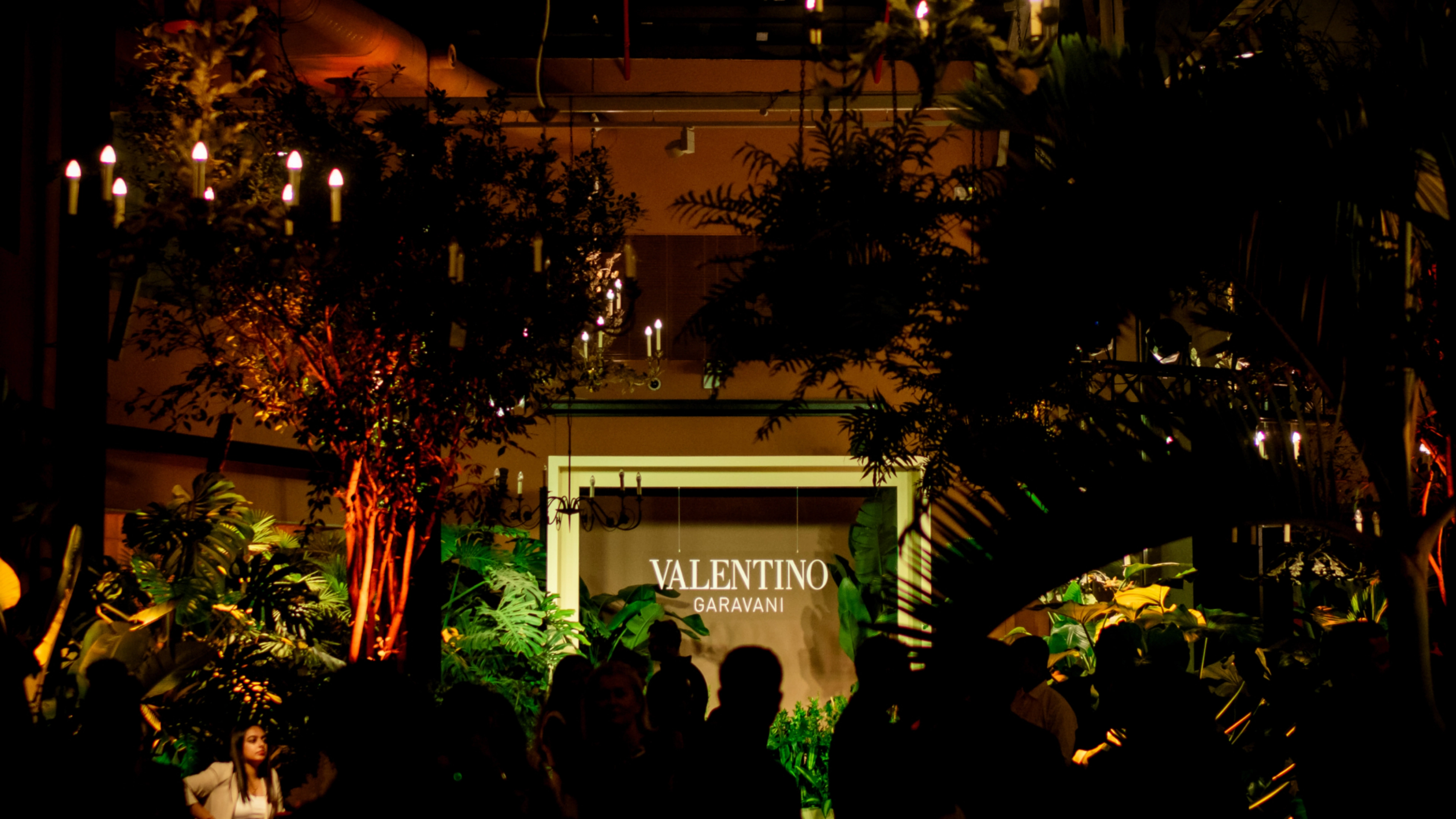 Valentino Diwali Dinner luxury fashion event - guests seated around an elegant ivory dining setup with premium tableware and floral centerpieces